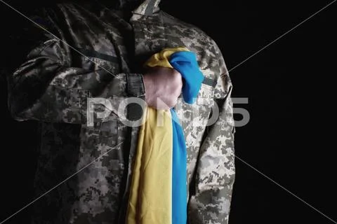 Ukrainian soldier holds in his hand the yellow-blue flag of the state Stock Photos