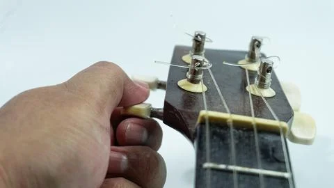 Ukulele with 4 strings being tuning on a white background Stock Photos