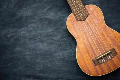 Ukulele on black cement background. Stock Photos