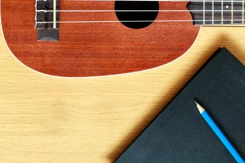 Ukulele guitar with  notebook and pencil Stock Photos