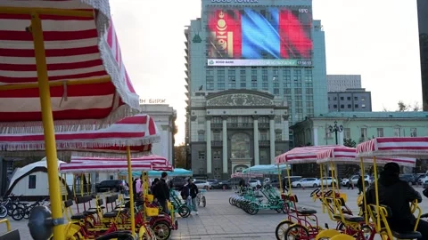 Ulaanbaatar Mongolia: Parked Surrey Bikes at Sukhbaatar Square &amp; Digital Flag Stock Footage 328401929