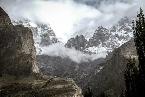 Ultar Sar mountain with snow capped and floating clouds. Hunza valley. Stock Photos