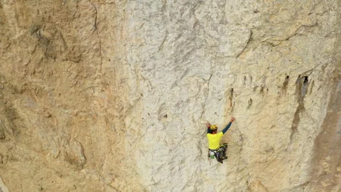 The Ultimate Ascent: Defying Gravity and Conquering Heights in a Daring Cliff Stock Footage 256240251
