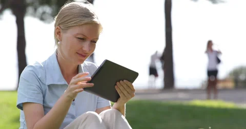 Ultra HD 4K Young Pretty Woman UseTablet Internet Search Shopping Online in Park Stock Footage 32244870