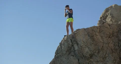 Ultra slow motion of boy jumping from the cliff and diving into the sea Video stock 298934768