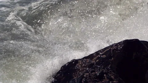 Ultra-slow motion waves crashing against a black rock Stock Footage 59546763