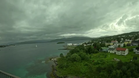 Ultra wide elevated view over coastal town, fjord, and sailboat in Senja Norway Stock-Footage 342340374