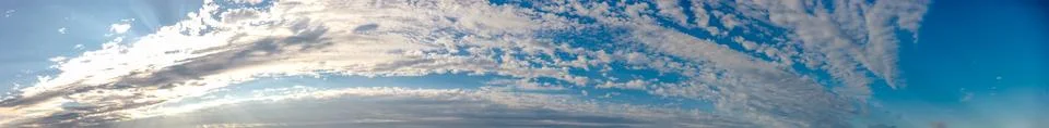 Ultra wide panoramic cloudscape with dramatic streaky clouds and sunlit edges Фото