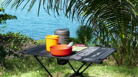 Ultralight kitchen set for traveling on a table, in nature with a tropical view Stock Footage 293694014