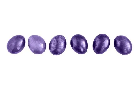 Ultraviolet Easter eggs in a row on isolated white background. Copy space. Stock Photos