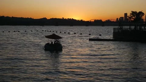 Umbrella boat float on water evening sunset orange sky Stock Footage 235400850