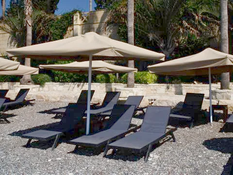 Umbrellas and sunbeds for relaxing on the beach 库存照片