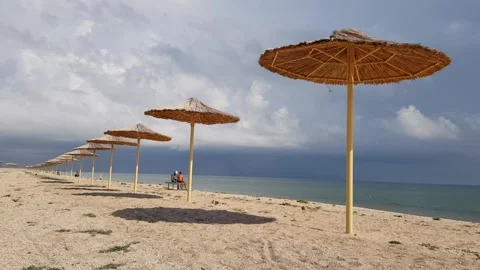 Umbrellas on the beach, beach umbrellas on an empty sea beach. Straw umbrella Stock-Footage 146779843