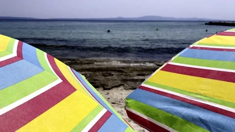 Umbrellas on the beach in slow motion Stock Footage 157863514