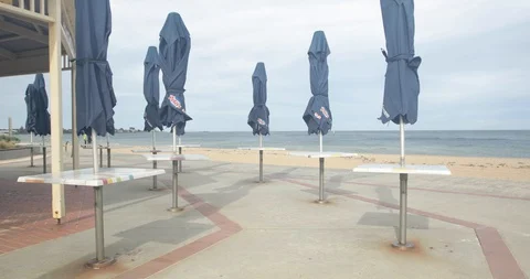 Umbrellas Blowing in Wind at Closed Outdoot Beach Cafe Coronavirus Shutdown Video stock 130155616