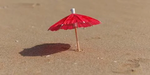 Umbrellas for cocktails stuck in the beach sand Stock Photos
