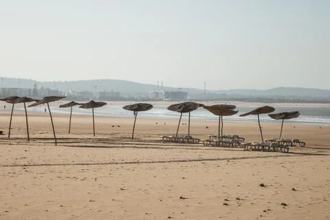 Umbrellas on an empty beach Stock Photos