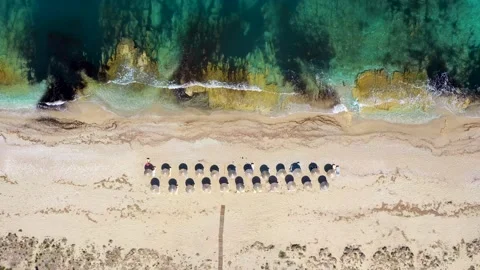 Umbrellas lined up on the sandy beach by the turquoise sea Stock-Footage 203820161