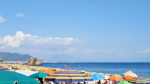 Umbrellas on the public beach - Pan Stock Footage 115160806