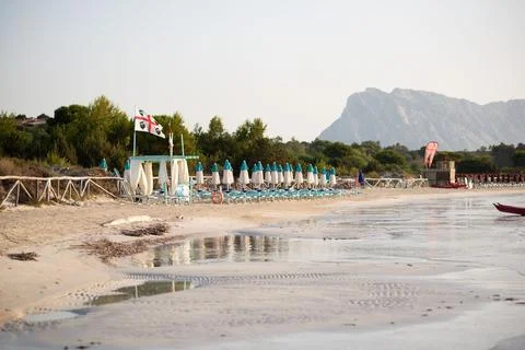 Umbrellas in a row on a beach with a mountain in the background Stock Photos