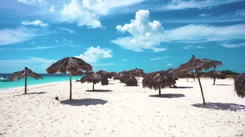 Umbrellas on the white sandy beach of Cayo Largo, Cuba. Azure water and white Stock Footage 71155732