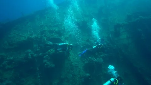 Umbria wreck  bow of the ship with divers in Red sea Port Sudan Sudan Stock Footage 87759318