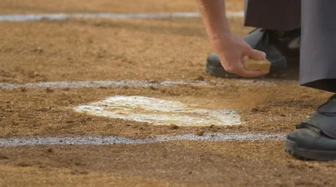 The umpire at a baseball game brushes off home plate, slow motion. Stock Footage