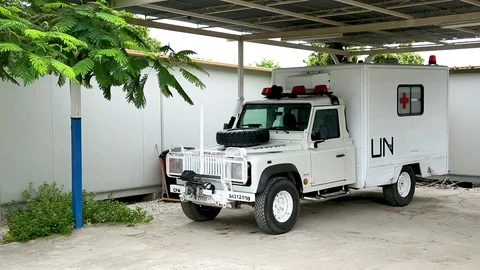 A UN ambulance sits stationary in a covered vehicle port Stock Footage