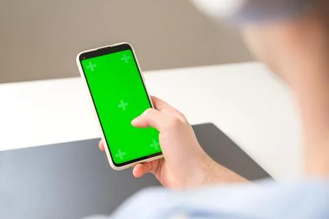 Un recognizable man using Smartphone with Green Chroma Key Screen. Mockup. Mo Stock Photos