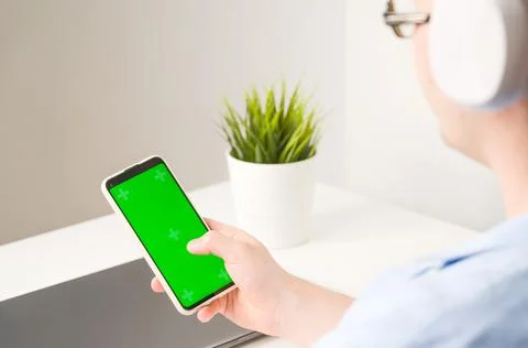 Un recognizable man using Smartphone with Green Chroma Key Screen foe educati Stock Photos