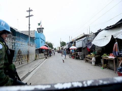 A UN soldier makes his way over to a another soldier on the other side of a gate Stock Footage
