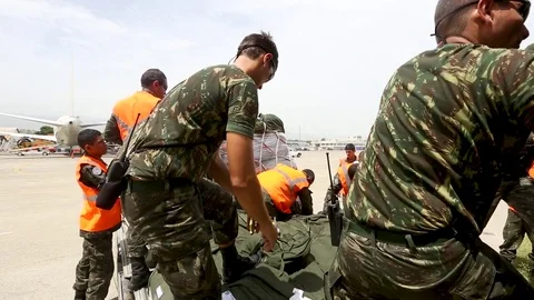 UN soldiers help each other load duffel bags Stock Footage