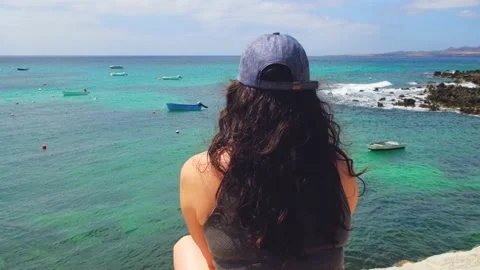 Una mujer con gorra contempla el mar en slowmotion 動画素材 158237666
