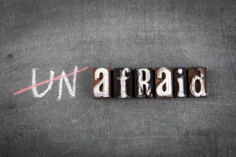 Unafraid and afraid concept. Word on a dark chalk board Stock Photos