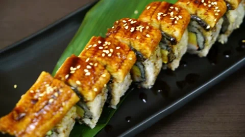 Unagi eel sushi roll on a black plate Stock Footage 336230824