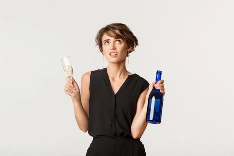 Unamused arrogant girl rolling eyes bothered, drinking champagne on boring party Stock Photos