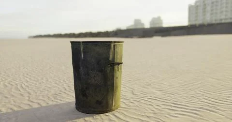 Unattended trash can on a sandy beach during sunset hours Stock Illustration
