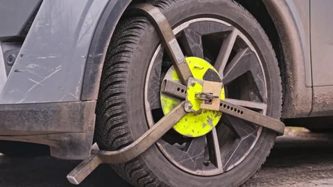 Unauthorised Illegal Parking Boot Wheel Clamp Deployed by Local Authorities Stock Footage 302906468