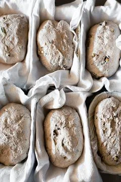 Unbaked bread in baskets on the table is proofing Stock Photos