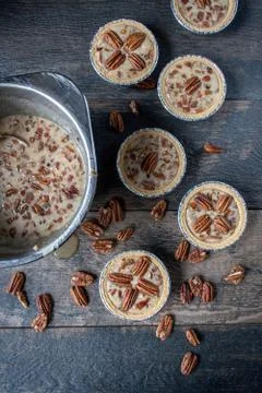 Unbaked mini pecan pies on rustic table flat lay Stock Photos