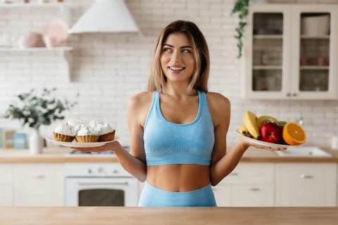 Uncertain lady making choice between eating healthier and treating herself Stock Photos
