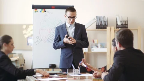 Uncertain young man in a jacket and glasses, says reports on the work done Stock Footage 119538824