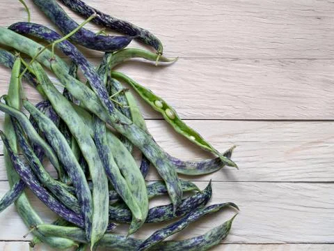 Uncleaned raw string beans lie on a plank background Stock Photos