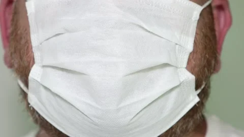 Uncomfortable man is trying to adjust mask with face movements Stock Footage 138659543