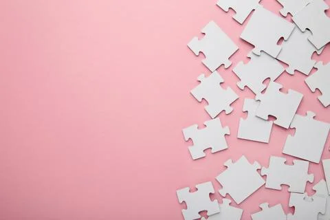 Uncompleted elements of a white puzzle on pink background. Space for text Stock Photos