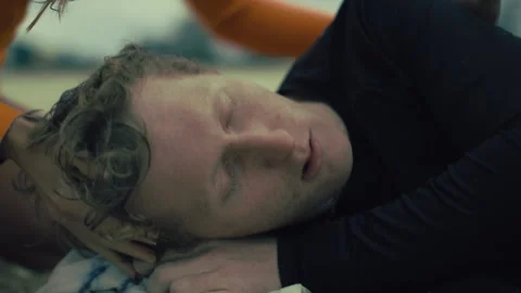 Unconscious man lying on the beach Stock Footage 263913892