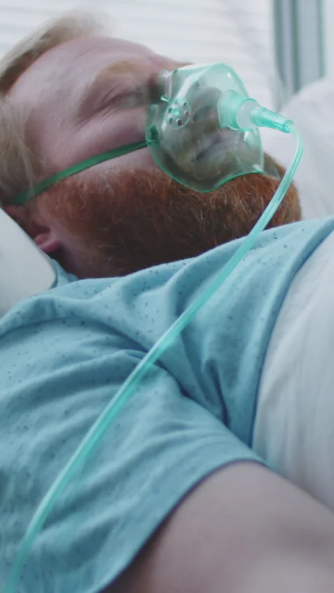 Unconscious Man Lying on Ventilator with IV Drip in Hospital Stock Footage 322599439