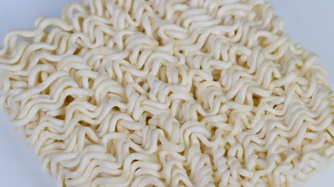 Uncooked beige wavy noodles. Closeup of pale beige crispy uncooked noodle brick Stock Footage 331753553