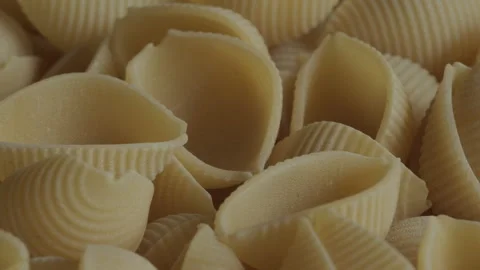 Uncooked conchiglie pasta rotating macro background. Stock Footage 283869171