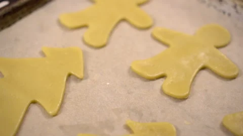 Uncooked cookie dough in the form of different figures is on a baking sheet. The Stock Footage 144388777